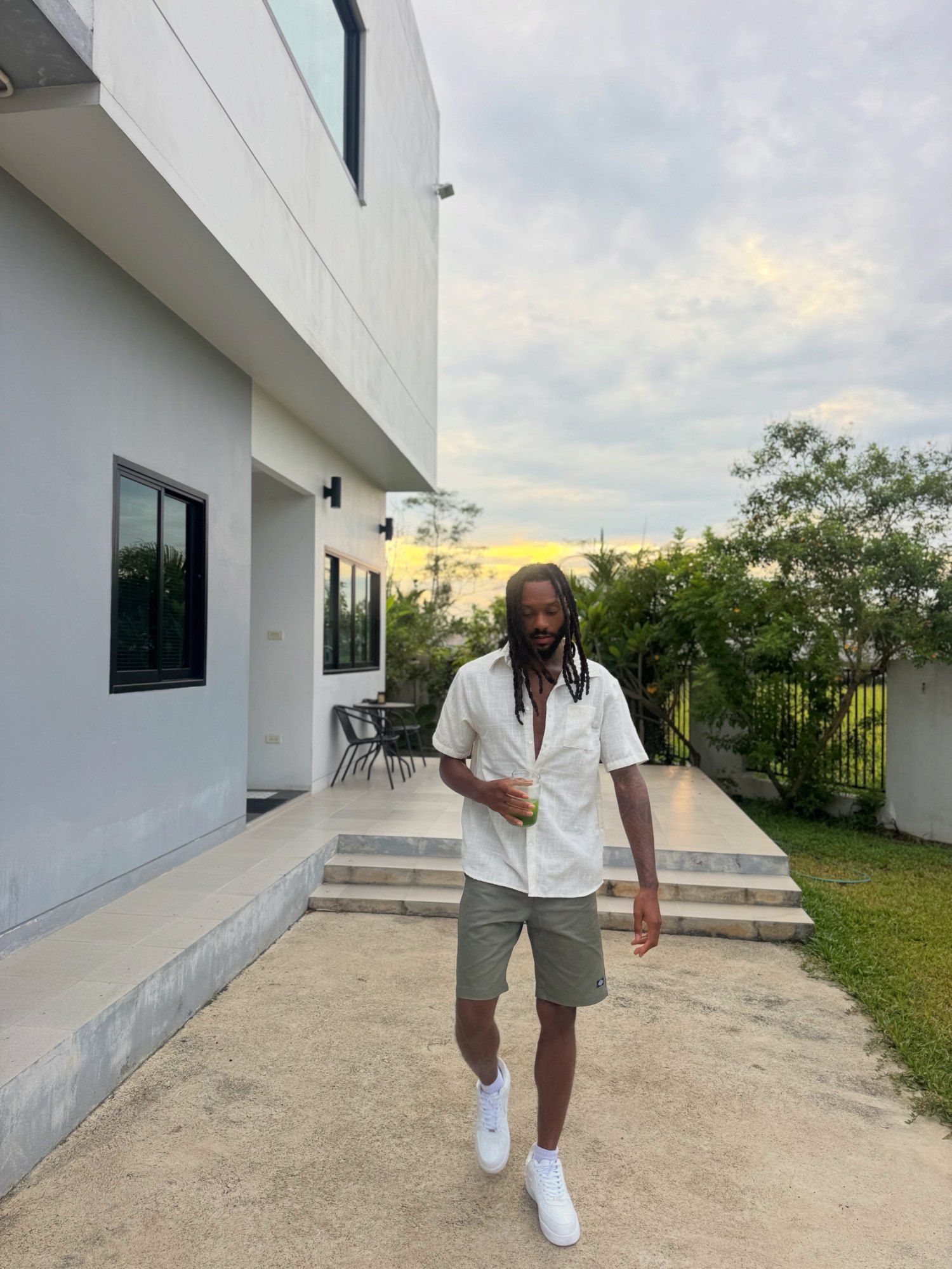 Rich Love walking outside at sunset with a green juice